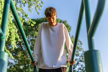 Young Man Working Out on Parallel Bars at a Park in the Afternoon