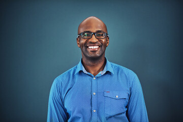 Fototapeta premium Happy, designer or portrait of black man in studio with pride, business and confidence for fashion. Startup, person or African entrepreneur with style, smile or glasses isolated on blue background