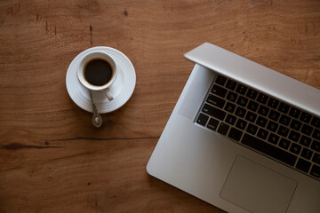Coffeetime at a desk with a laptop representing distant working in perfect details.