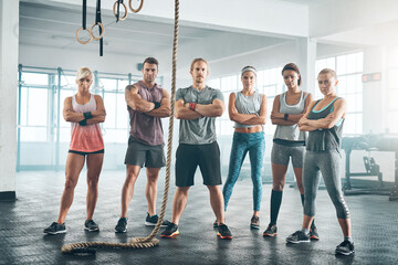 Fototapeta premium Rope, portrait and group of athletes in gym for health, wellness and body workout challenge. Fitness class, friends and team of people with personal trainer for exercise together in sports center.