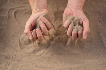 Sand of time. Close-up of sand falling from man's hand. Hand releasing dropping sand. Fine Sand flowing pouring through fingers. Time passing concept