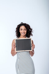 Fototapeta premium Beautiful young woman holding a chalkboard sign with space for ad copy or messaging. Copy Space
