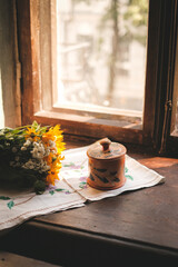 Vintage wooden jewelry box placed on a windowsill, with soft natural light illuminating the scene. 