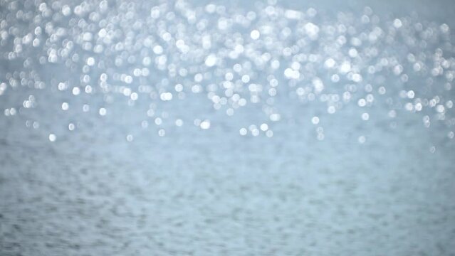 Sun glare on the surface of the water. Bokeh. River flow. Background. Out of focus.
