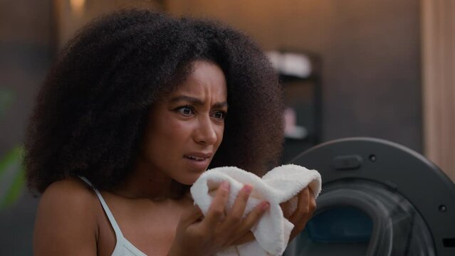 African American woman girl female sad failure frustrated frown lady housework housewife open door broken washing machine laundry bad terrible smelling sniff odor smell aroma white towel gel mistake