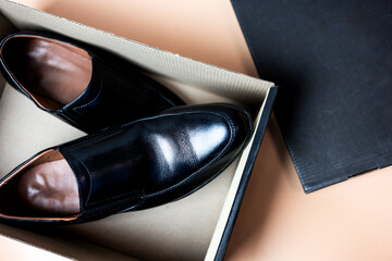 Male black leather shoe, new product on brown box, comfortable footwear for businessman or office workers. Open box