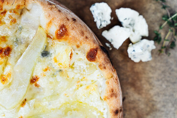 Rustic pizza with a golden, crispy crust, garnished with fresh ingredients like blue cheese and herbs