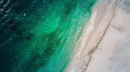 "Tranquil white sandy beach with crystal-clear emerald waters. Aerial view capturing the serene blend of sea and shore."