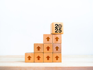 2025 year number with target icon on big wood cube on many blocks as growth graph steps with rise up arrow sign on white background. New trends, business goal, financial economic improvement concept.