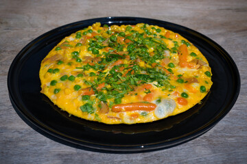 ready to eat - a vegetable omelet served on a black plate