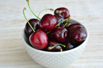 ripe cherries in a white bowl isolated close up  