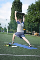 A young man in sportswear engages in a workout, using a sport tool for physical exercises on a...