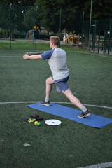 A young man in sportswear engages in a workout, using a sport tool for physical exercises on a...