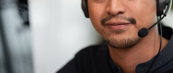 Closeup Asian male call center, customer service, telesales wearing headset or headphone talking with customer