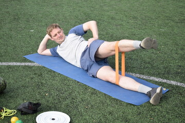 A young man in sportswear engages in a workout, using a sport tool for physical exercises on a...