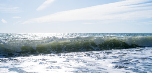 Sea wave close-up, water splash in the sea, sea foam against the sky on a summer sunny day
