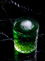 Tarragon lemonade glass with ice isolated on black 