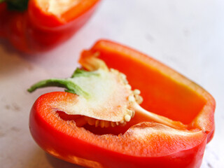 A red bulgarian pepper, paprika vegetable, cut, lies on a white background, on a table. Healthy nutrition, vegetarianism, crop production, vegetable garden