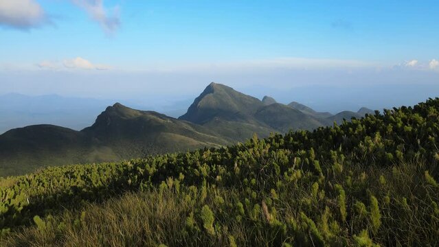 Voo sobre montanhas pico camapu&atilde; relevando agudos da cotia ao fundo, sobre caratuvas ao vento na serra do ibitiraquire