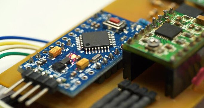 Stepper Motor Driver. Small electronic circuit with burning red LED light bulb. Microcircuit with electronic components connected to power supply. Microcircuit, resistors and chips