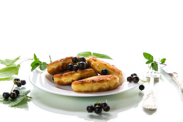Fried curd cheese pancakes with black currants, isolated on white background