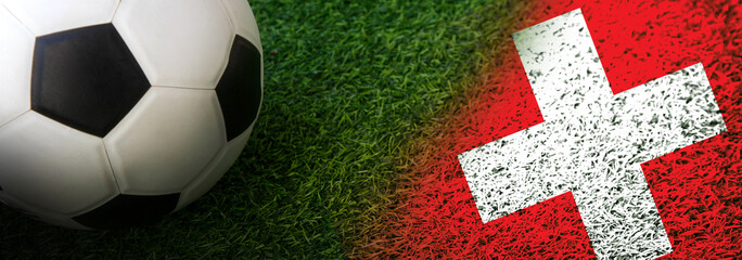 Soccer ball on green grass with Switzerland nation flag banner; Football Euro 2024 tournament