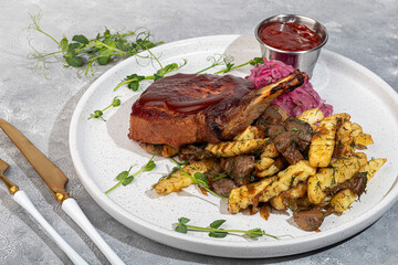 Meat on the bone with fried potatoes and mushrooms. Hot lunch.
