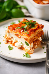 closeup shot, slice of cottage cheese lasagna on a white plate, with a fork