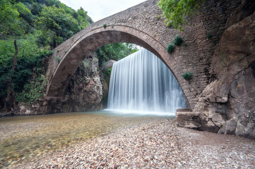 Amazing picture with the picturesque old stone bridge at Palaiokarya waterfalls near Trikala in Greece.