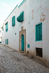 Obraz premium Traditional blue Tunisian metal door with a pattern in a white building in the city of Sidi Bou Said in Tunisia in the summer on a sunny day