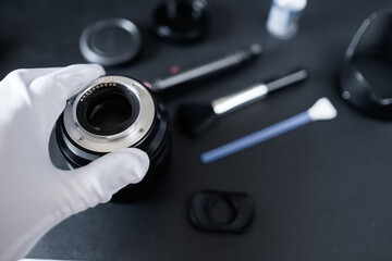 Cleaning camera lens camera gear and equipment using brush cleaning tools, professional hands...