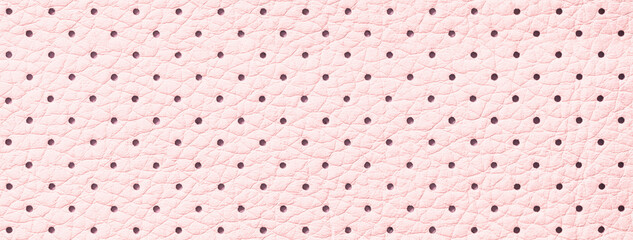 Perforated pink leather texture background, closeup. Light backdrop from wrinkle skin.