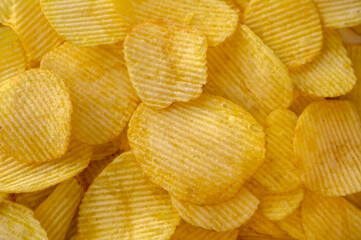 Close-up view of abundant crispy potato chips filling the frame for a textured background 1