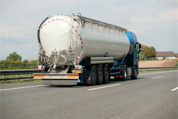 Petrol truck on highway hauling fossil oil refinery products. Fuel delivery transportation....