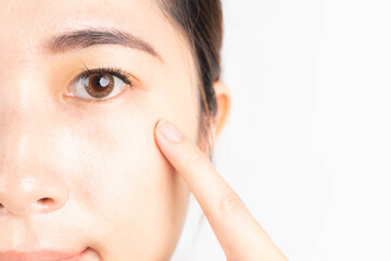 Beauty asian woman touching her healthy eyes over white background. Optimal eyes health care...