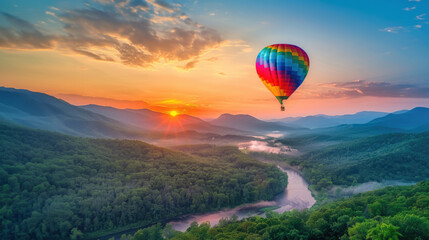 Naklejka premium Colorful hot air balloon flying over green valley with road and mountain background at sunrise, bucket list lifestyle concept