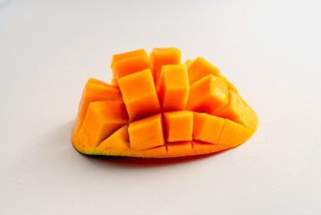 half mango cut in horizontal rectangles on white background