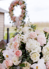 Decoration of fresh flowers for a wedding ceremony or restaurant. Beautiful fresh flowers in the form of roses decorate the area. Round wreath of fresh flowers