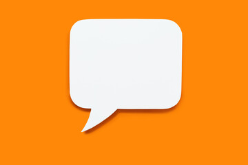 Paper speech bubble in the shape of a rectangle on a orange background. Flat white chat icon in the form of an empty speech bubble. Free space for text or image. Internet communication concept