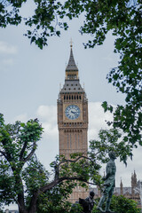 Big Ben Clock Tower Framed by Trees and Statue