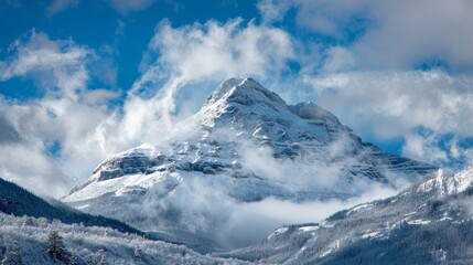 Snow-dusted mountain peak partially obscured by clouds in a scenic landscape capture.