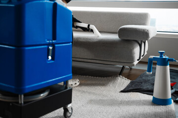 Extracting dust and dirt, removing spots from sofa using extractor to clean upholstered furniture. Refreshing sofa and cushions from dust and dirt with dry-cleaning extractor.