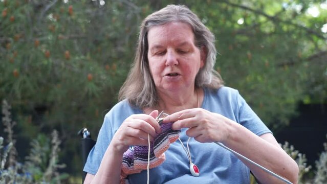 65 year old woman knitting outdoors