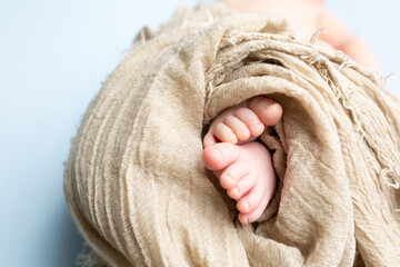 small feet of a newborn on a blue background. soft focus