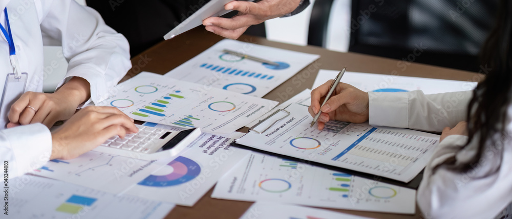 Aufkleber business team discussing analysis and planning in a meeting with charts and graphs on the table