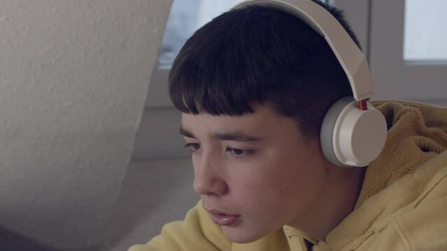 Adolescente mirando el ordenador con cascos