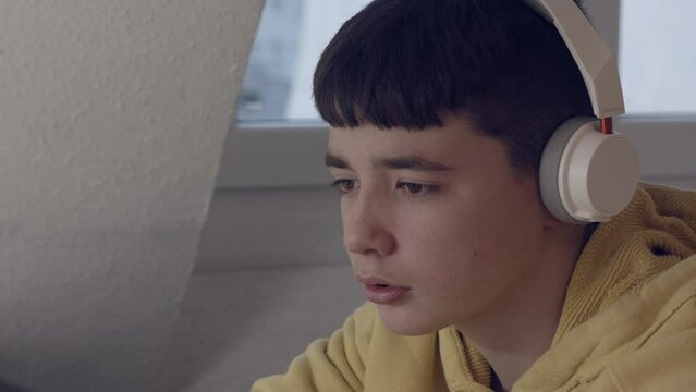 Adolescente mirando el ordenador con cascos