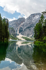 Natural landscapes of the lake Braies (Lago di Braies) with morning sunlight and mirror-like reflections on the mountain peak in Dolomites, Italy