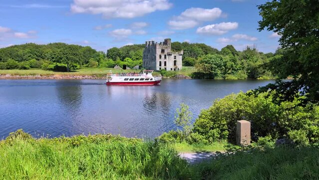  Corrib princess ship cruising in the Corrib river by Menlo castle, Galway, Ireland, medieval architecture, nature background