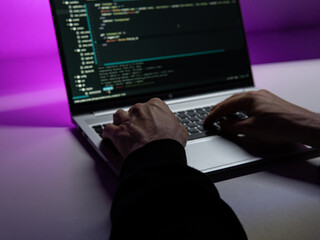 the programmer works in his home office. in the dark with backlight.